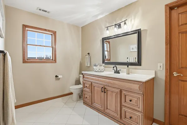 a bathroom with a granite countertop toilet a sink and a mirror