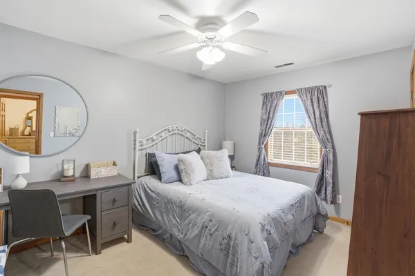 a bedroom with a bed a mirror and a window