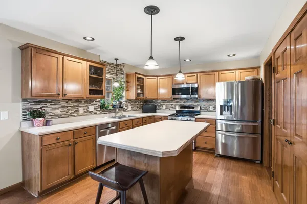 a kitchen with a refrigerator a sink and chairs