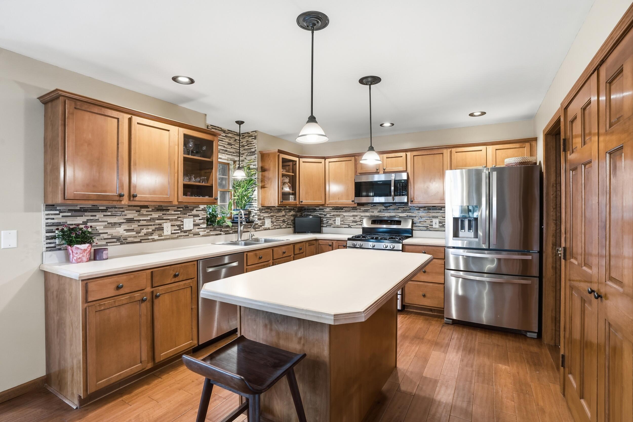11063 Marion Place Crown Point, IN 46307 - Photo 6 of 22 a kitchen with a refrigerator a sink and chairs