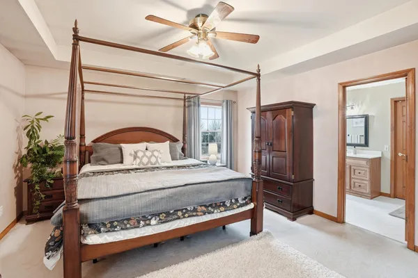a spacious bedroom with a bed and a dresser