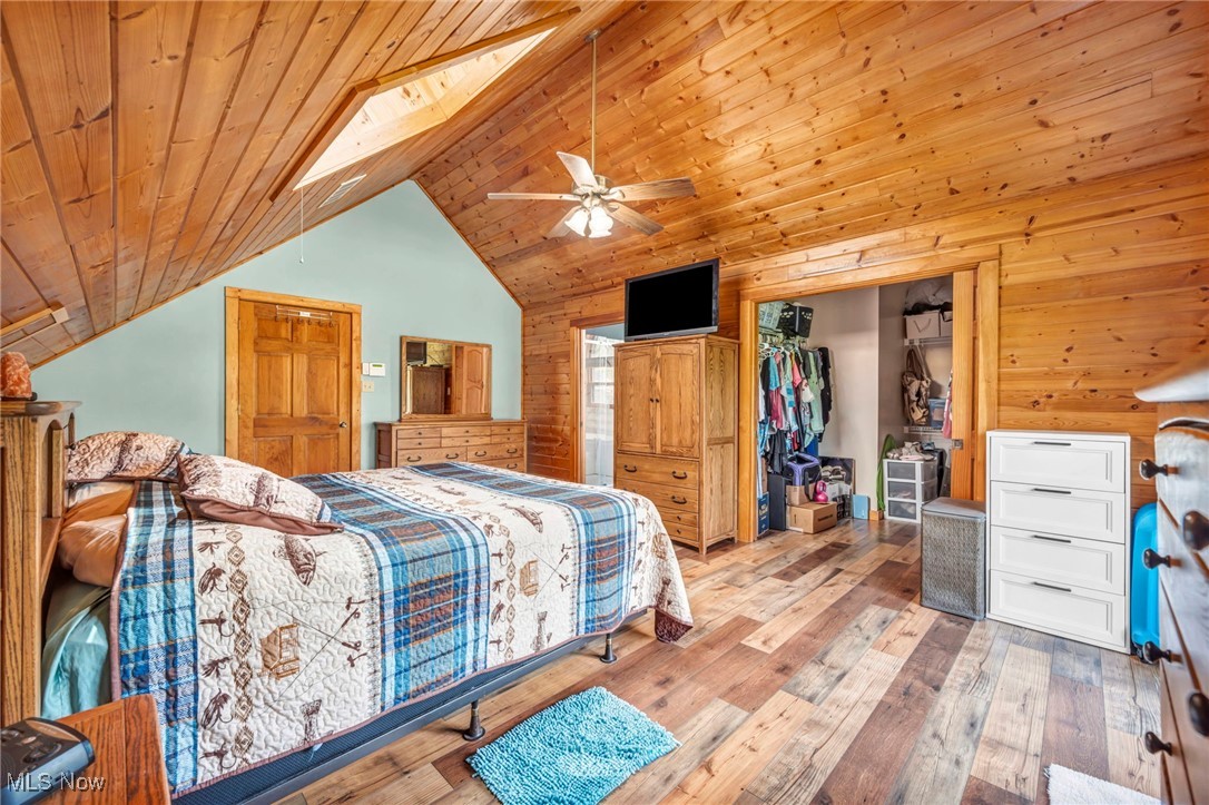 15180 Stoltz Road Diamond, OH 44412 - Photo 23 of 48 Bedroom with vaulted ceiling, wood-type flooring, wood ceiling, a closet, and wood walls
