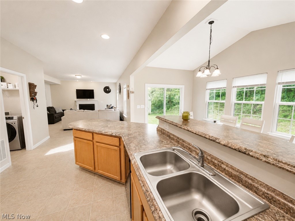 867 Starr Ridge Street Southeast Massillon, OH 44646 - Photo 9 of 29 Kitchen island with a double basin stainless steel sink, light brown cabinetry, and an extended countertop