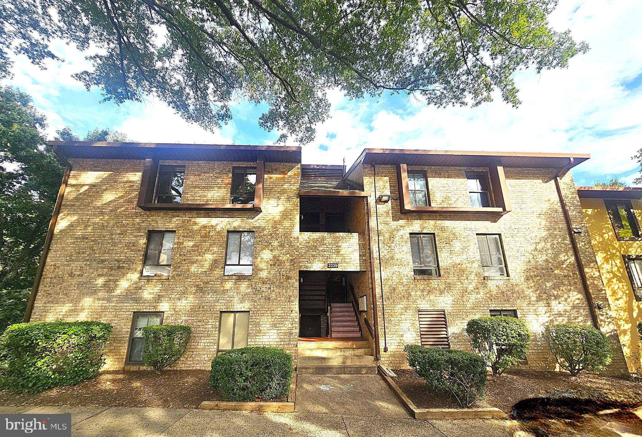 2239 Castle Rock Square, Unit 21C Reston, VA 20191 - Photo 1 of 30 a front view of a house with a garden