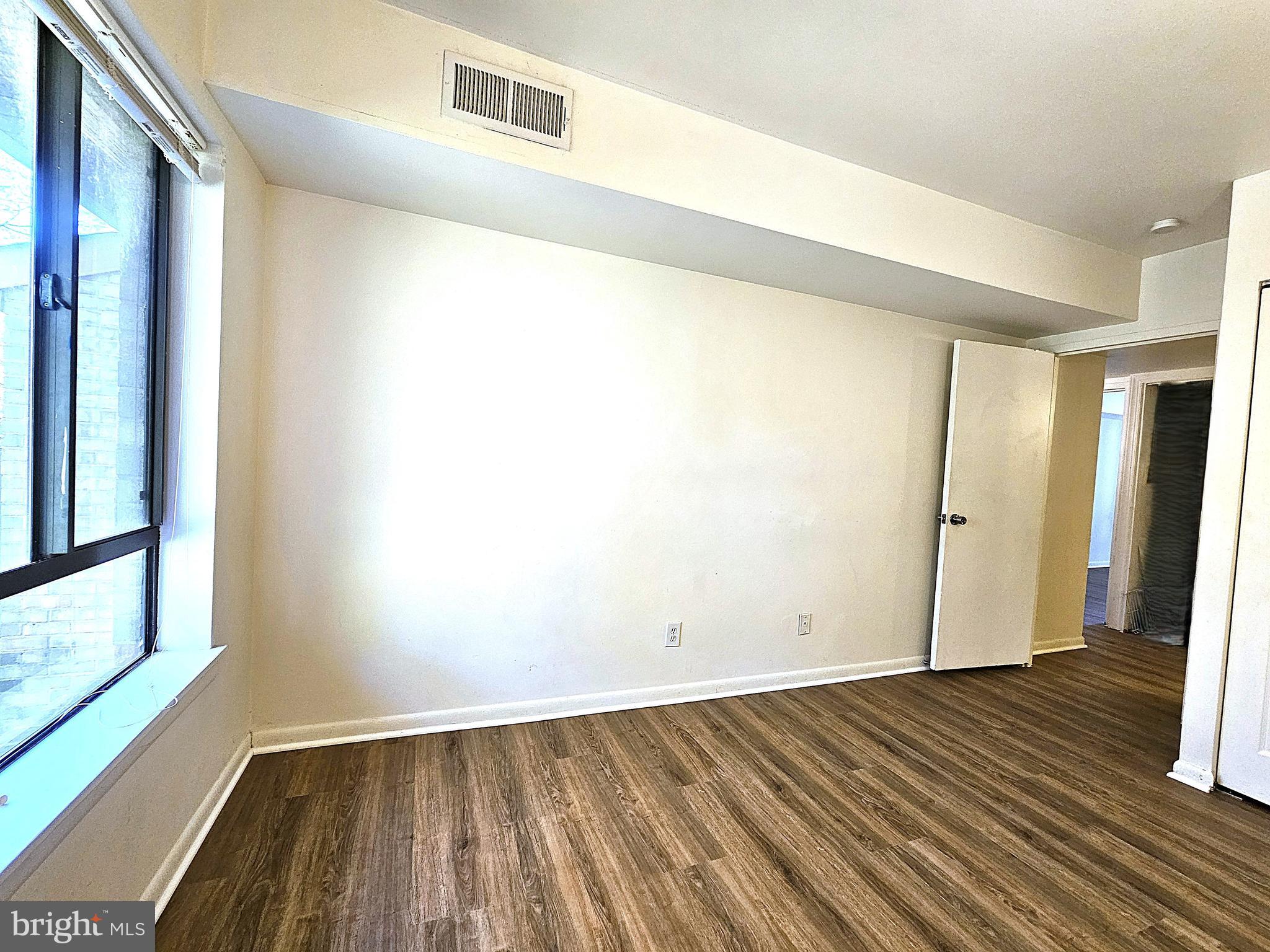 2239 Castle Rock Square, Unit 21C Reston, VA 20191 - Photo 20 of 30 a view of an empty room with wooden floor and a window