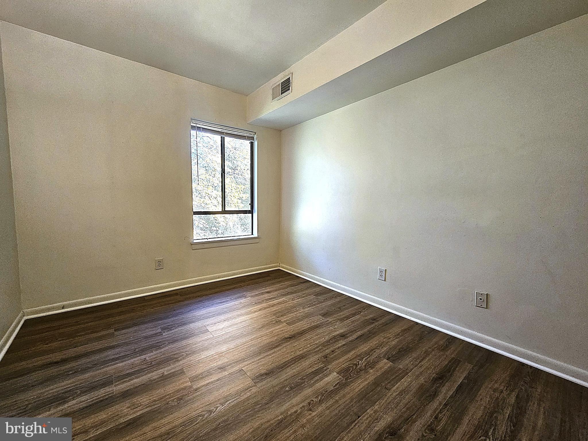 2239 Castle Rock Square, Unit 21C Reston, VA 20191 - Photo 26 of 30 an empty room with wooden floor and windows