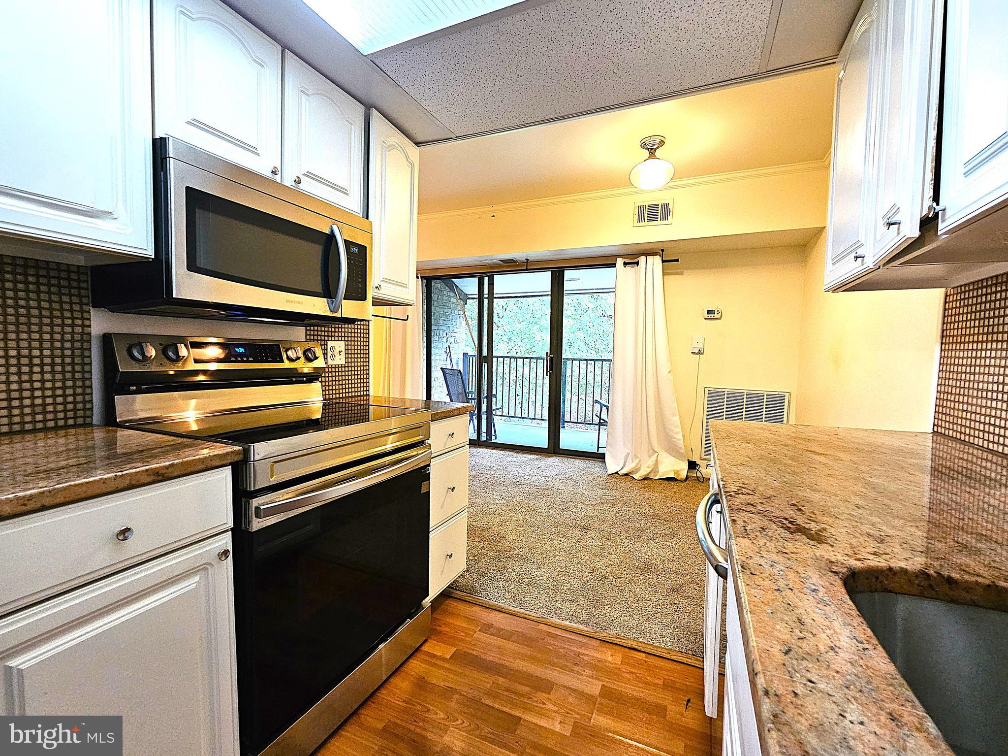 2239 Castle Rock Square, Unit 21C Reston, VA 20191 - Photo 4 of 30 a kitchen with a stove a sink and a microwave