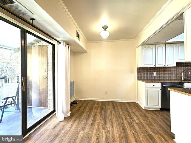 a kitchen with a refrigerator and wooden cabinets