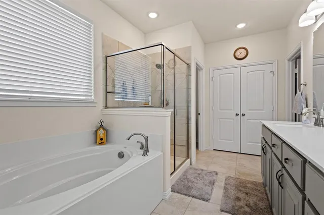 a bathroom with a bathtub a sink a vanity and a shower