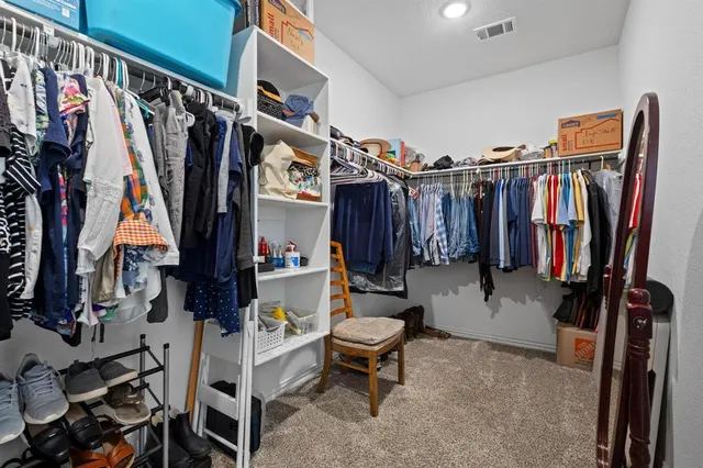 a view of walk in closet with clothes and shoes