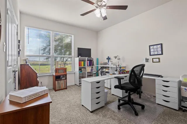 a view of a workspace with furniture and a window