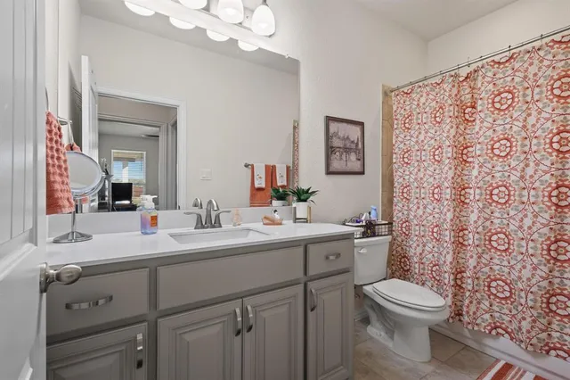 a bathroom with a toilet a sink a vanity and mirror