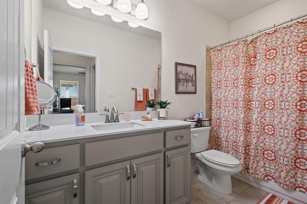 1875 Whitemound Road Sherman, TX 75090 - Photo 27 of 40 a bathroom with a toilet a sink a vanity and mirror