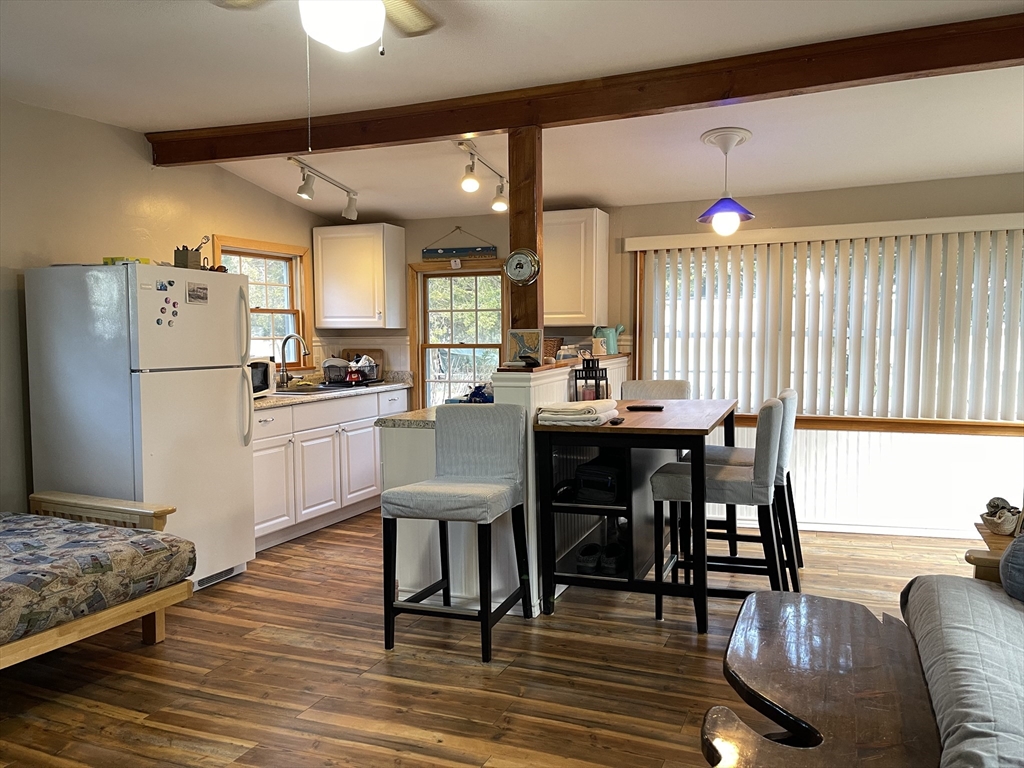 1634 Drift Road, Unit T Westport, MA 02790 - Photo 7 of 18 a kitchen with stainless steel appliances kitchen island granite countertop a table chairs and a refrigerator