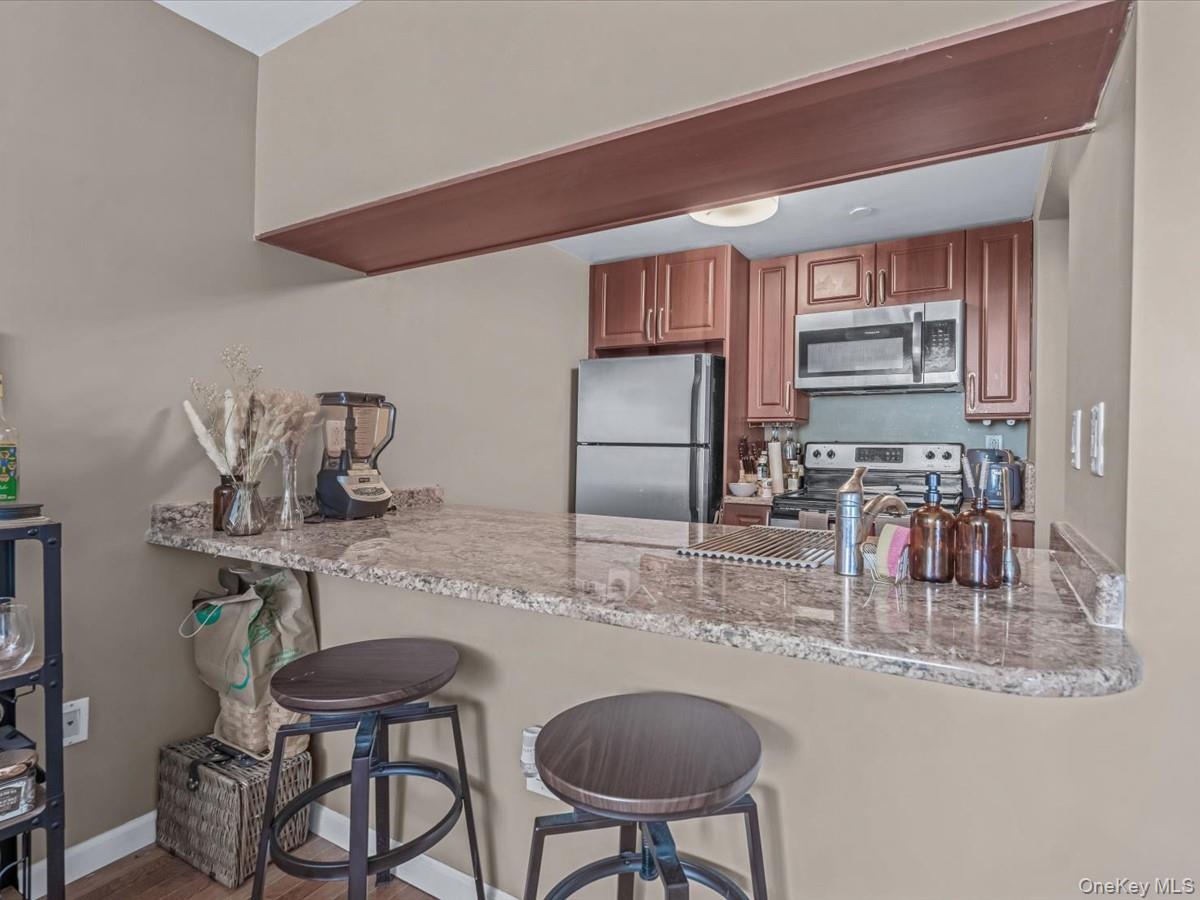 358 Grove Street, Unit 2E Brooklyn, NY 11237 - Photo 5 of 15 a kitchen with stainless steel appliances granite countertop a sink and a refrigerator