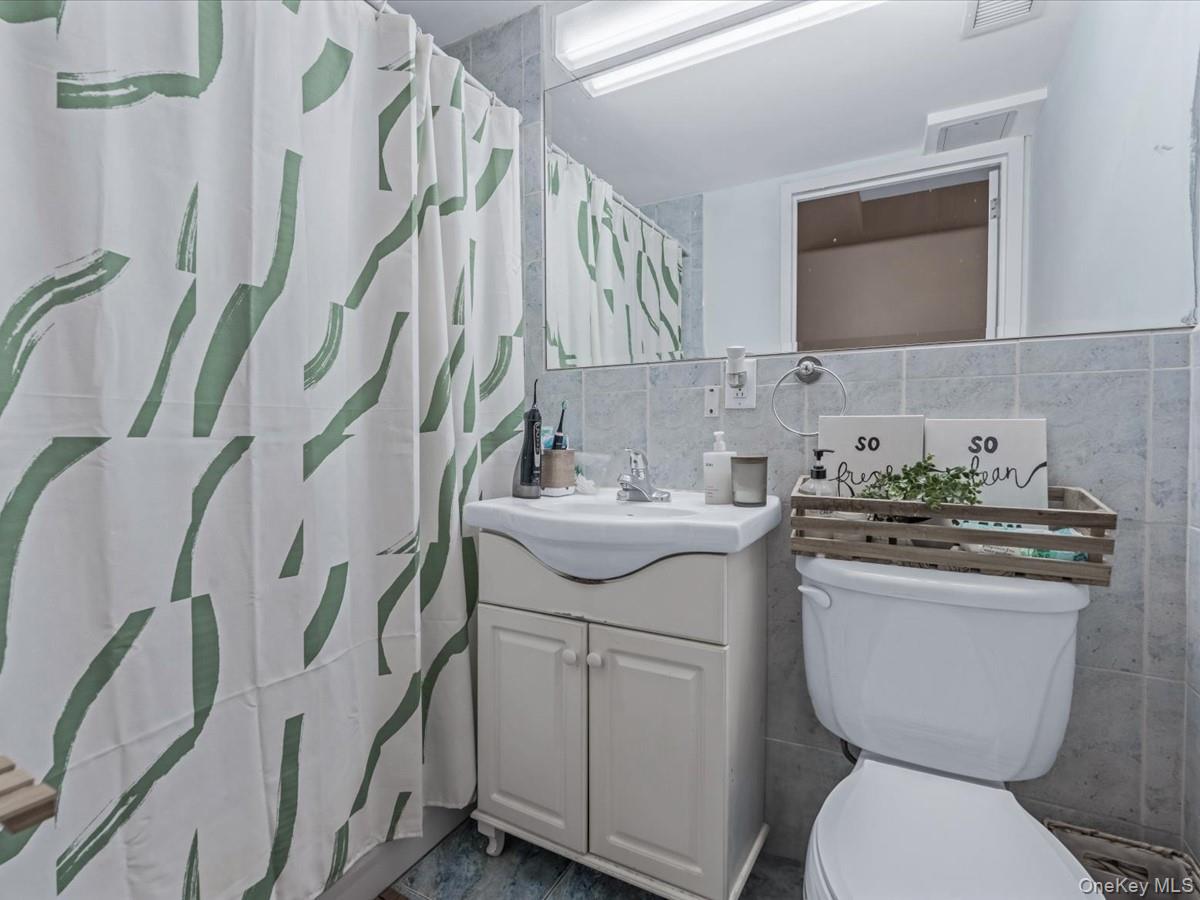 358 Grove Street, Unit 2E Brooklyn, NY 11237 - Photo 10 of 15 a bathroom with a toilet sink and mirror