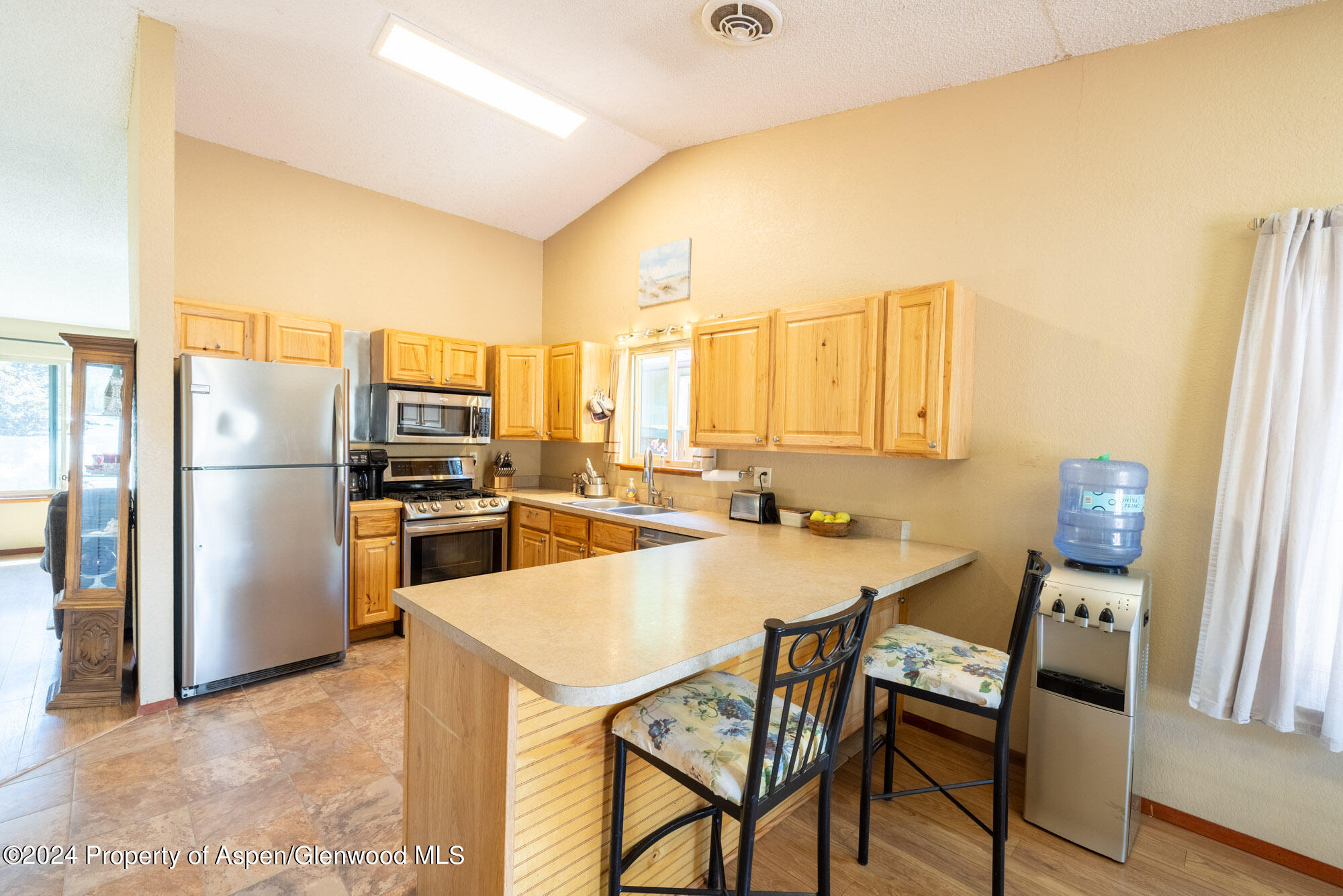 720 East 5th Street Rifle, CO 81650 - Photo 7 of 27 a kitchen with a table chairs refrigerator and cabinets