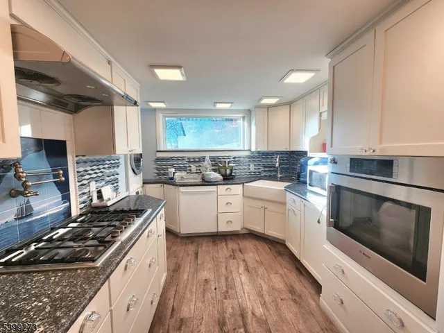 a kitchen with kitchen island a stove a sink and a refrigerator