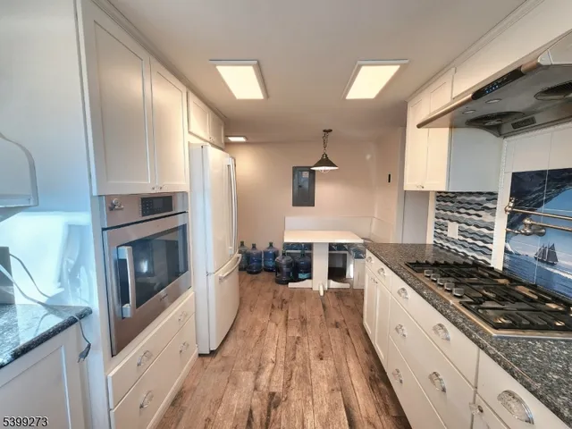 a kitchen with granite countertop a sink stove and refrigerator
