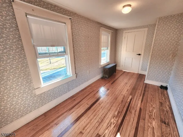 a view of an empty room with a fireplace and a window