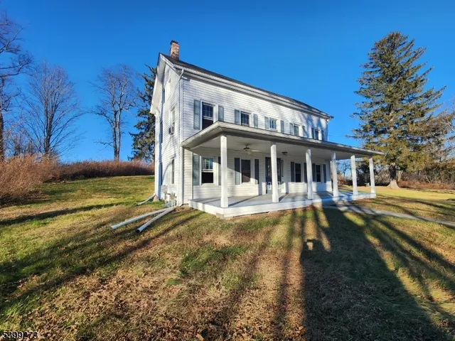 a view of a house with a swimming pool and sitting area