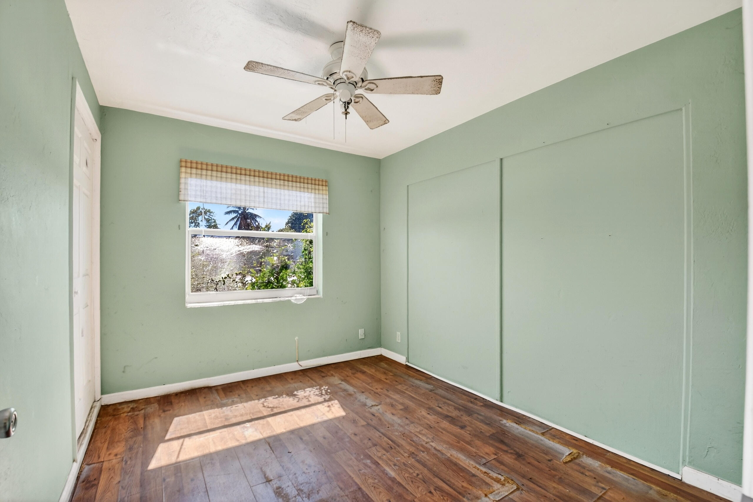 2013 Longwood Road West Palm Beach, FL 33409 - Photo 13 of 41 an empty room with wooden floor fan and windows