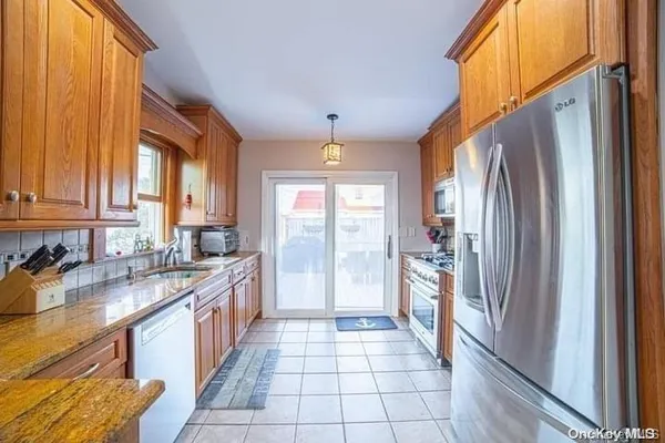 a large kitchen with a refrigerator a sink dishwasher a stove and a refrigerator with wooden floor