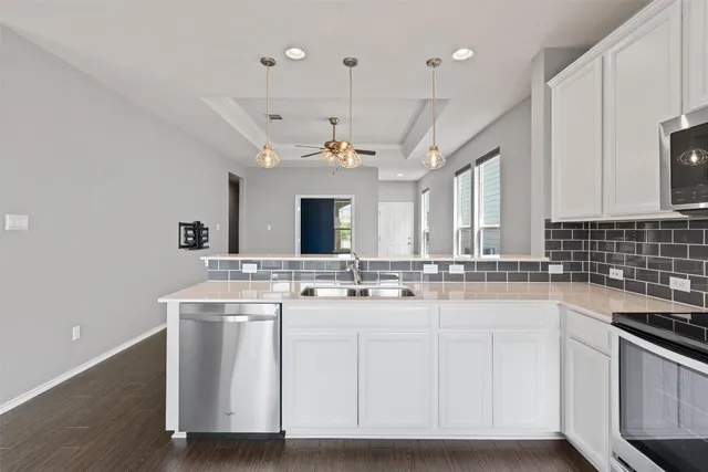 a kitchen with kitchen island granite countertop a sink cabinets and stainless steel appliances