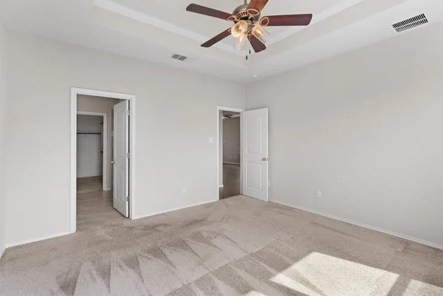 a view of a room with a ceiling fan and window