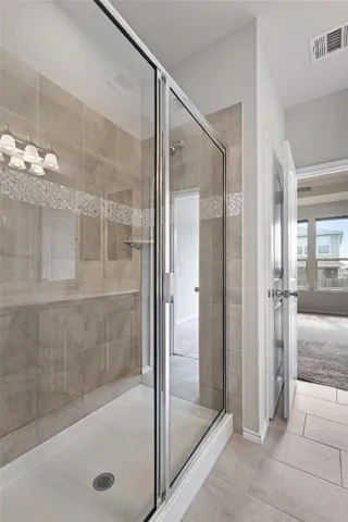 a bathroom with a glass shower door and a sink