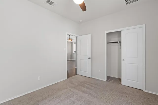 an empty room with closet and windows
