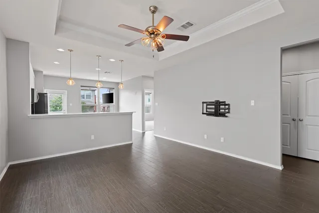 a view of an empty room with window and wooden floor
