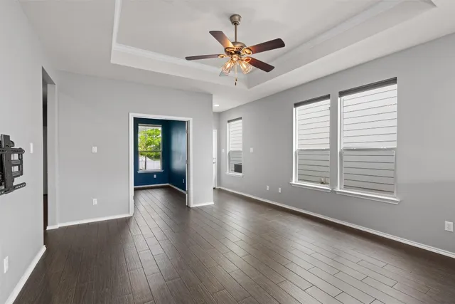 a view of an empty room with a window and wooden floor