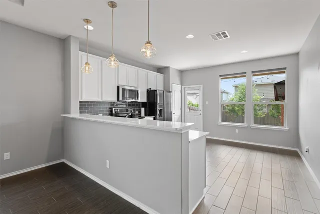 a kitchen with stainless steel appliances a refrigerator sink and microwave