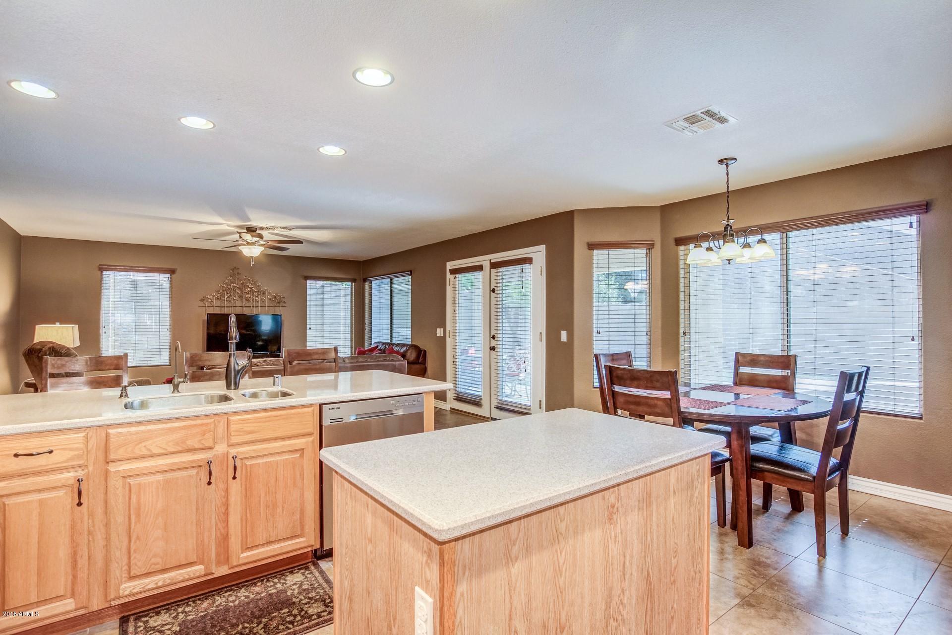 16033 South 18th Drive Phoenix, AZ 85045 - Photo 11 of 30 a large kitchen with kitchen island a sink table and chairs