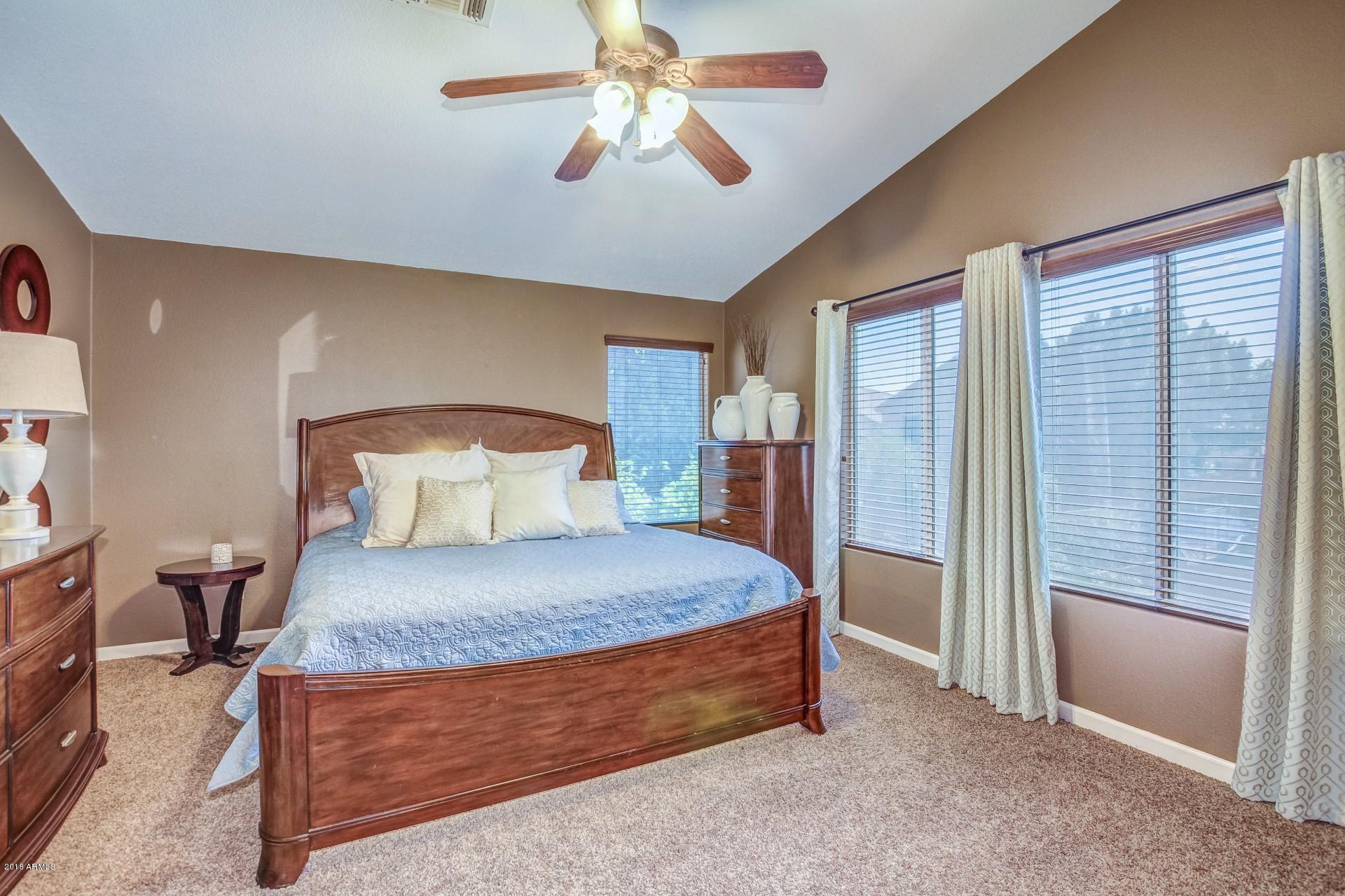 16033 South 18th Drive Phoenix, AZ 85045 - Photo 15 of 30 a spacious bedroom with a bed and a chandelier