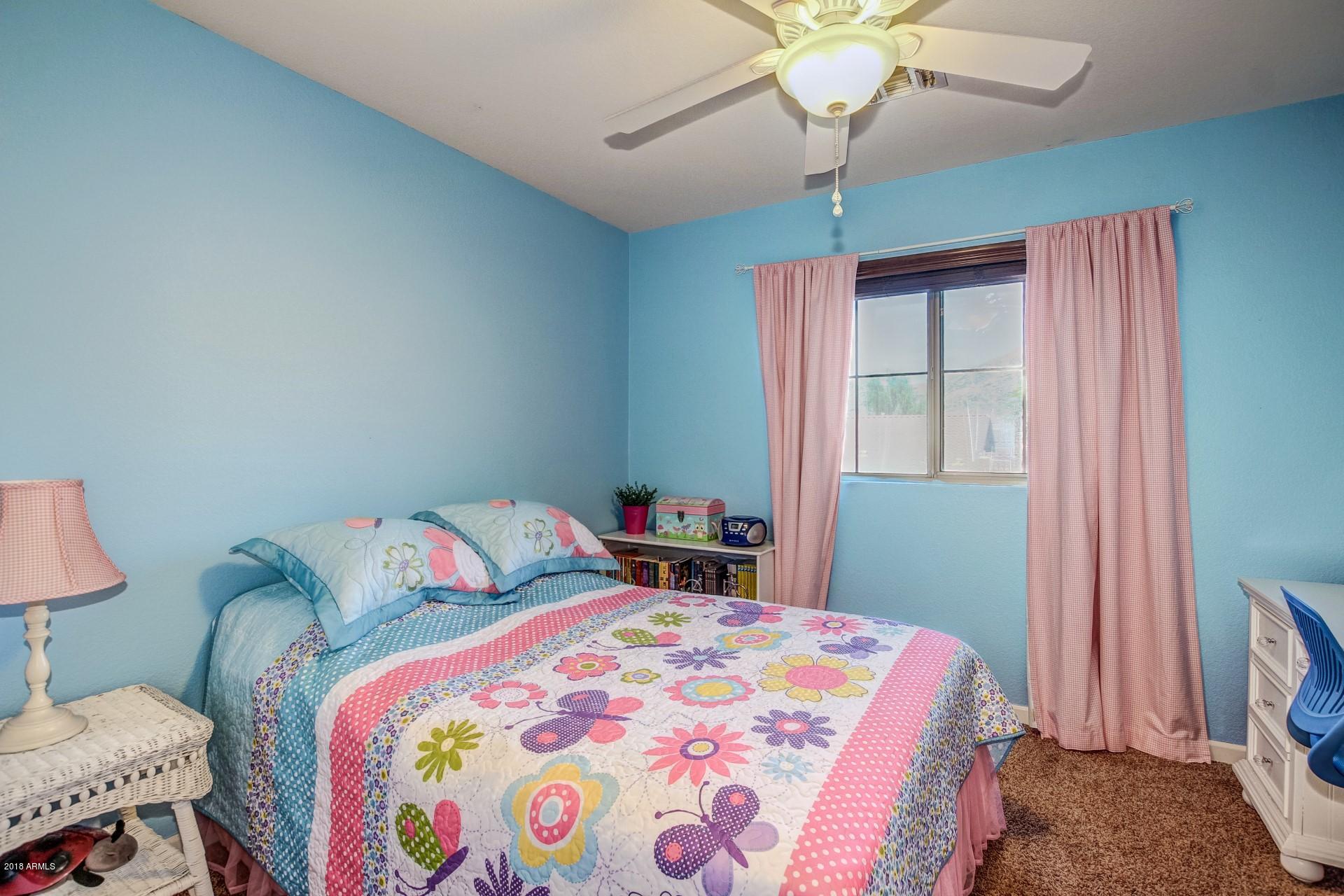 16033 South 18th Drive Phoenix, AZ 85045 - Photo 22 of 30 a bedroom with a bed and a chandelier
