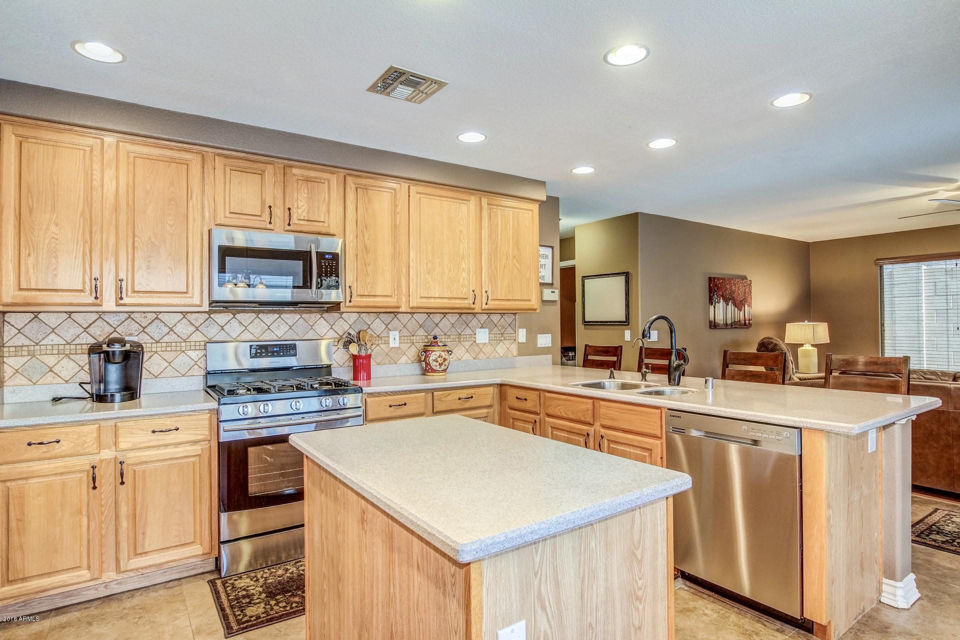 16033 South 18th Drive Phoenix, AZ 85045 - Photo 10 of 30 a kitchen with stainless steel appliances granite countertop refrigerator stove microwave and sink