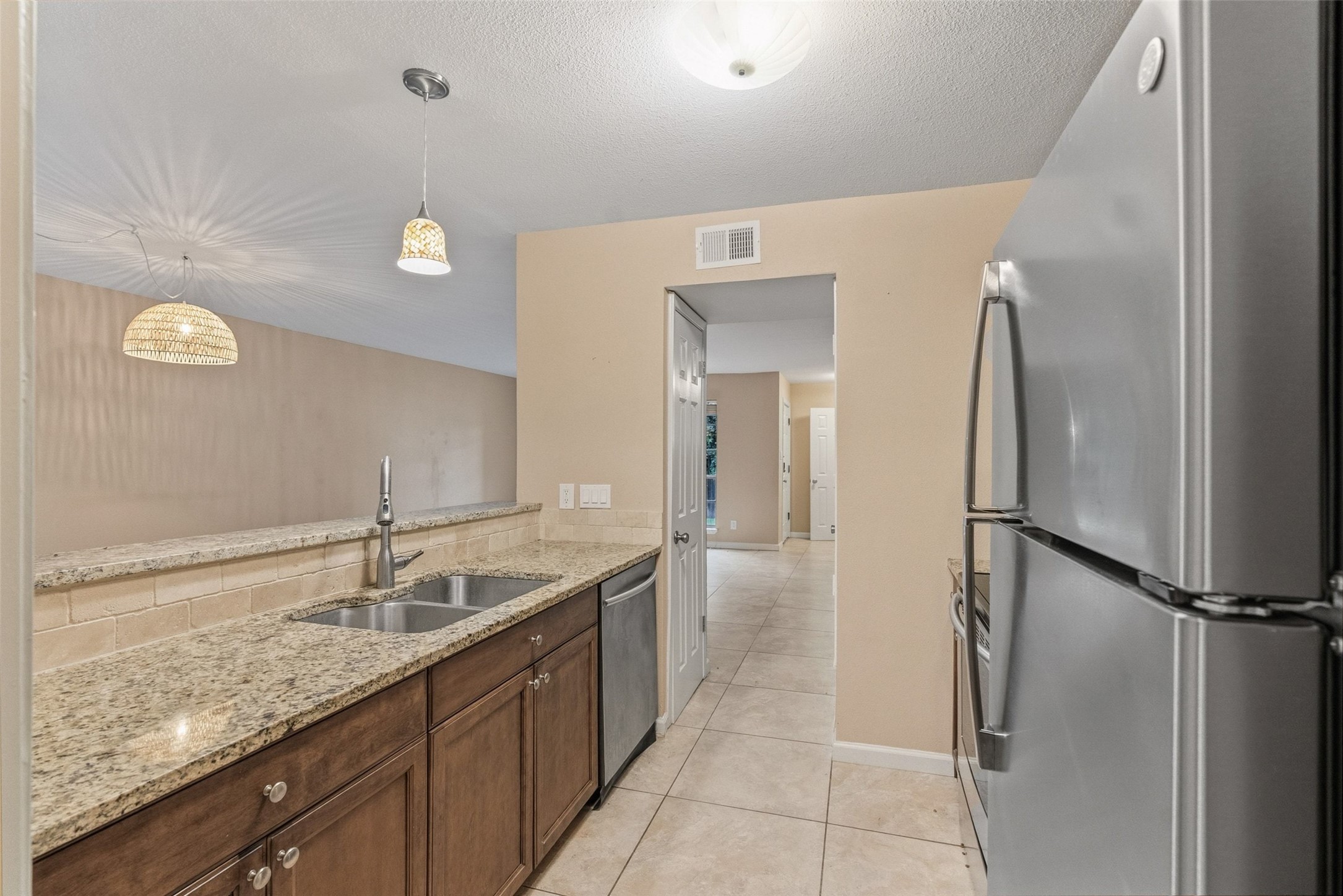 702 Castle Ridge Road, Unit C Austin, TX 78746 - Photo 34 of 36 This updated two-story residence offers approximately 1,144 square feet with 2 bedrooms, 1.5 bathrooms, and an open floor plan filled with natural light. Features include vinyl and tile flooring throughout with no carpet, granite countertops, and a walk-in shower. The main level features a comfortable living area that flows into the dining space and kitchen, creating an ideal setting for daily living and entertaining.