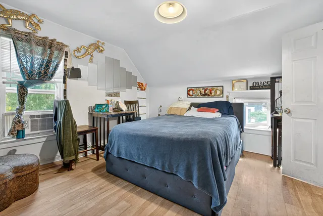 a bedroom with a bed and wooden floor