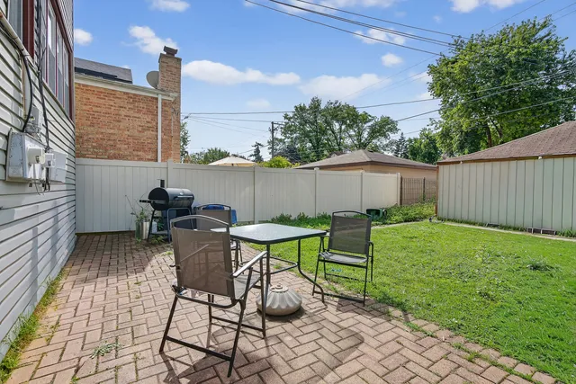 a view of a chairs and table in backyard of the house