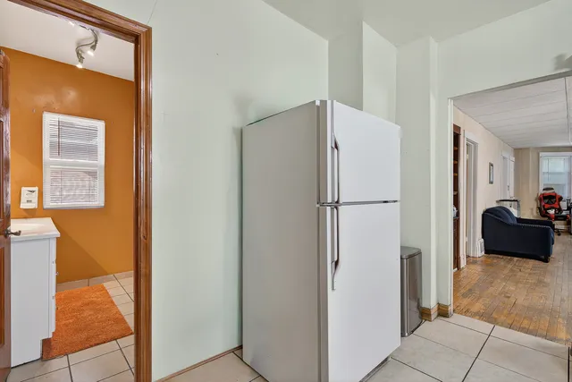 a refrigerator freezer sitting in a kitchen with stainless steel appliances wooden floor
