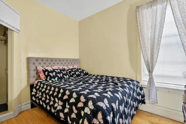 a bed sitting in a bedroom next to a window