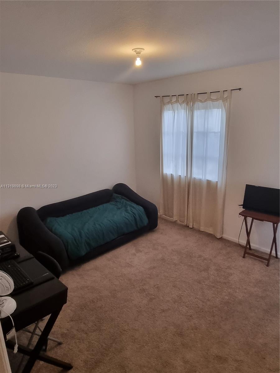 27534 Southwest 140th Avenue Homestead, FL 33032 - Photo 13 of 25 a bedroom with a bed and a chair