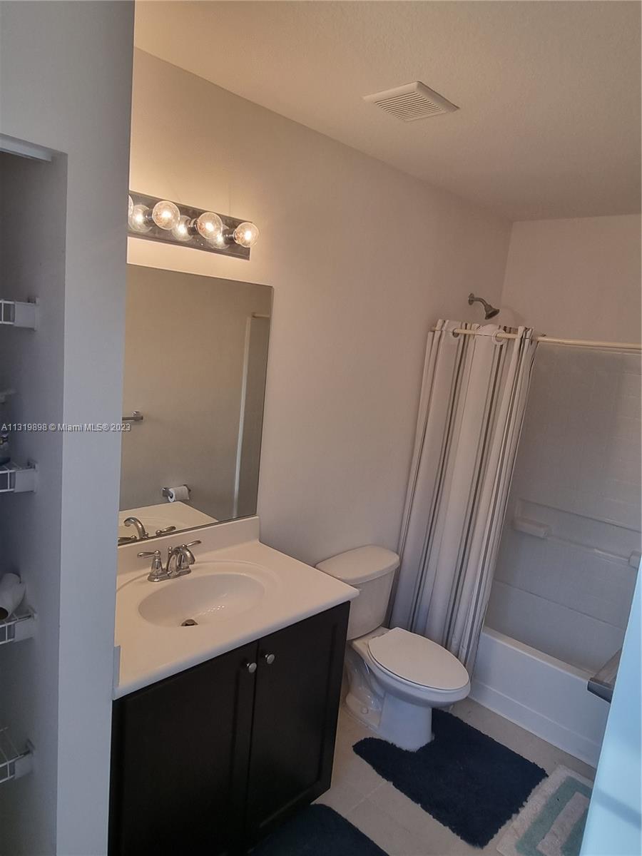 27534 Southwest 140th Avenue Homestead, FL 33032 - Photo 17 of 25 a bathroom with a sink a toilet a mirror and shower