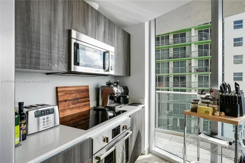 a kitchen with stainless steel appliances a stove top oven a sink a counter space and cabinets