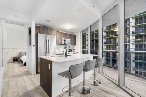 a kitchen with refrigerator a sink and chairs