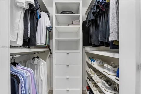 a view of walk in closet with clothes and shoes