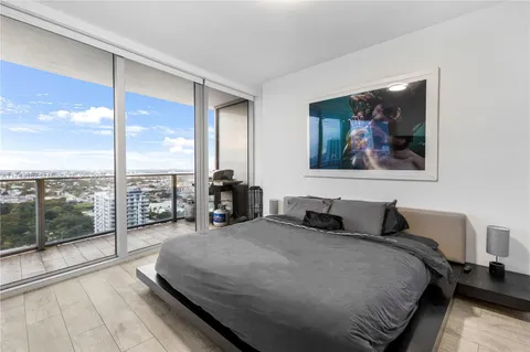 a bedroom with a large bed and a balcony view