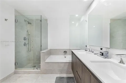a bathroom with a double vanity sink mirror double and shower